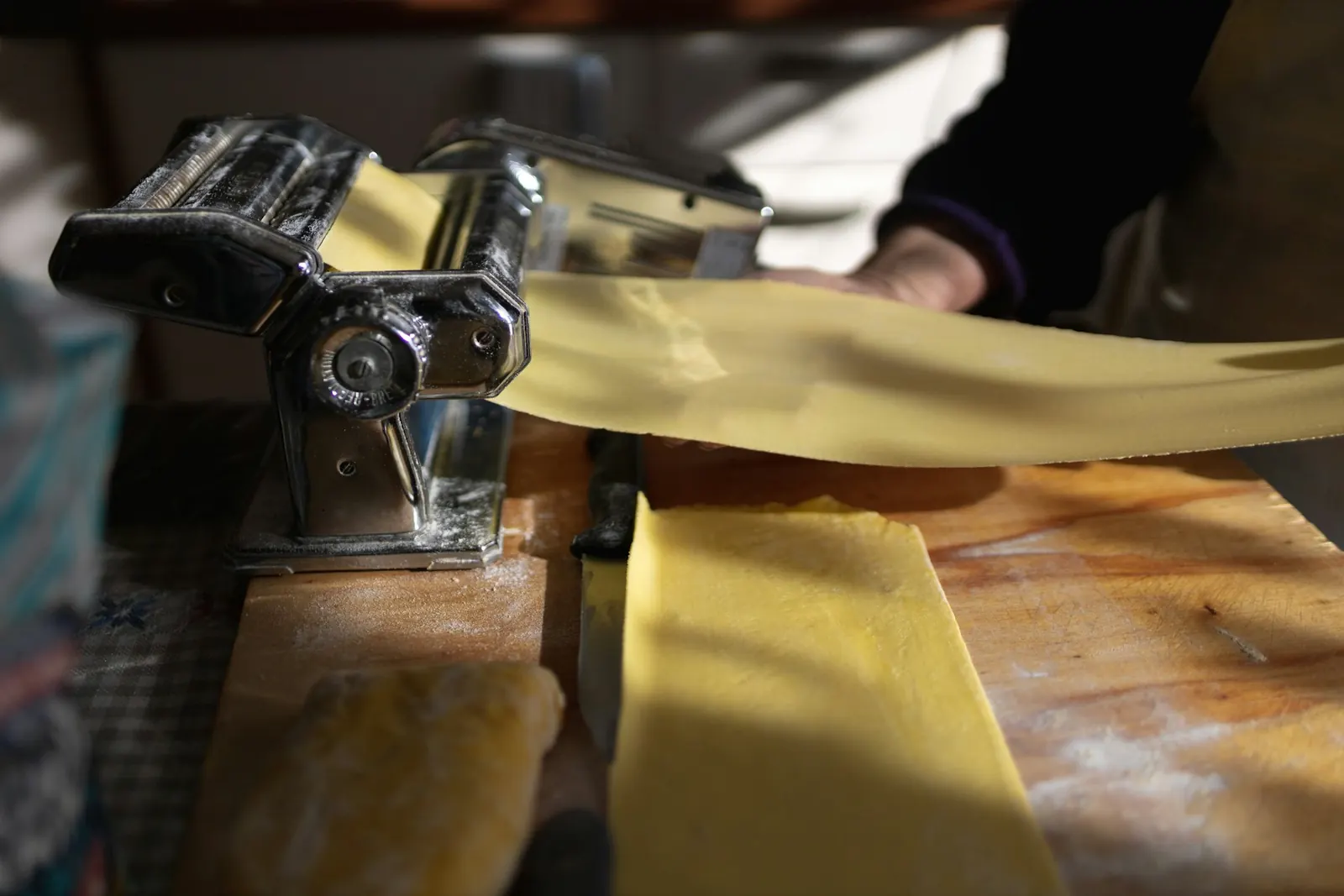 La macchina per la pasta e una sfoglia gialla appena tirata